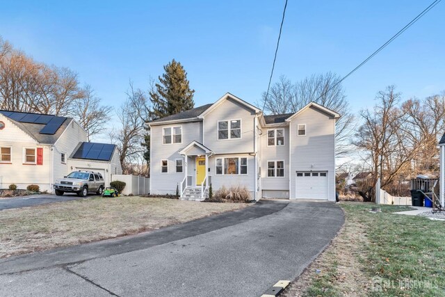 front facade with a garage, a front lawn, and solar panels