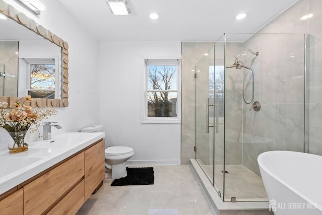 full bath featuring double vanity, a stall shower, toilet, a freestanding tub, and a sink