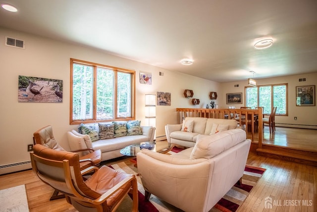 living room with light wood finished floors and a baseboard heating unit