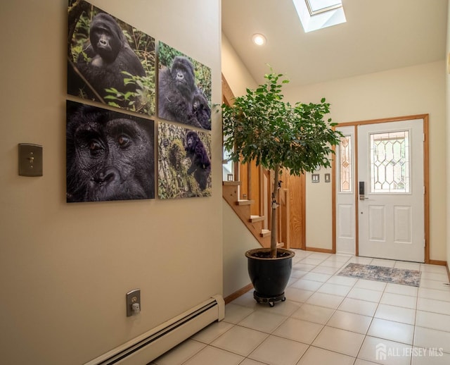 foyer featuring a skylight, baseboard heating, stairway, light tile patterned floors, and baseboards