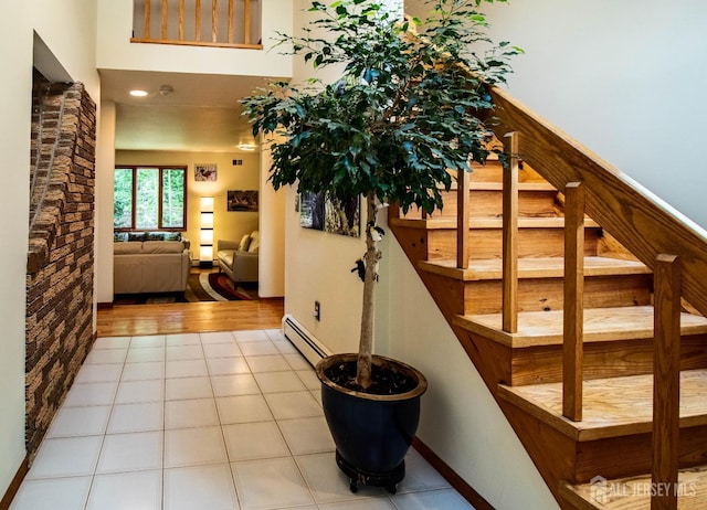 tiled foyer featuring a baseboard radiator and baseboards