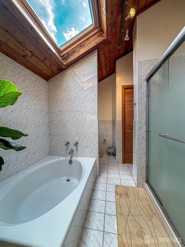 bathroom with tile walls, wood ceiling, a skylight, a stall shower, and marble look tiles