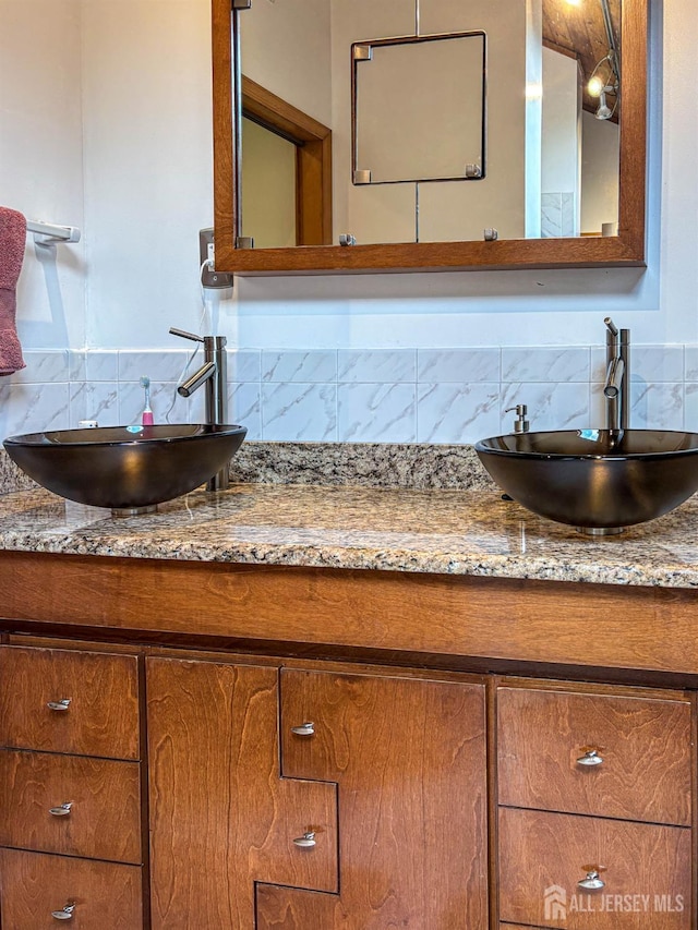 bathroom featuring backsplash and double vanity