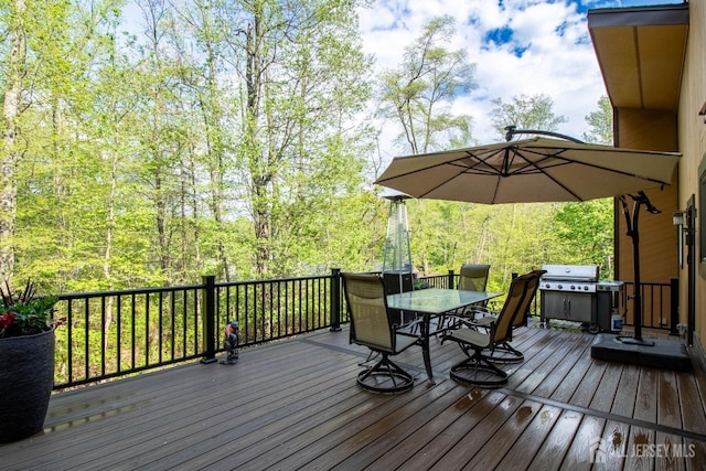 deck featuring outdoor dining area and a grill
