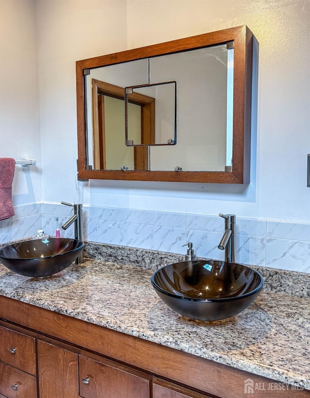 bathroom with tasteful backsplash and vanity