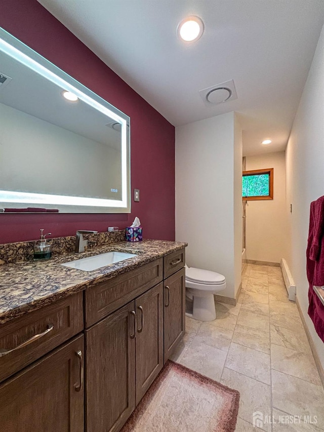 bathroom with a baseboard heating unit, toilet, vanity, recessed lighting, and a shower
