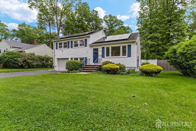 606 Hayward St, Bound Brook, NJ 08805 - tri-level home with driveway, roof mounted solar panels, and a garage
