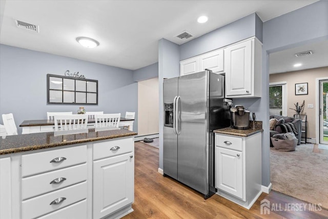 606 Hayward St, Bound Brook, NJ 08805 - kitchen featuring stainless steel fridge, white cabinets, baseboard heating, dark stone countertops, and wood finished floors