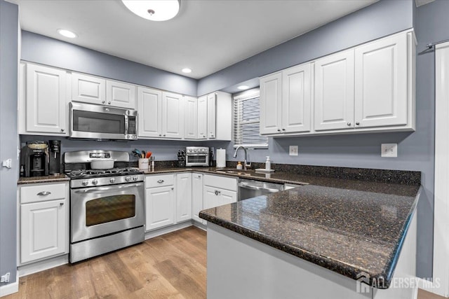 606 Hayward St, Bound Brook, NJ 08805 - kitchen featuring appliances with stainless steel finishes, white cabinets, light wood-type flooring, and recessed lighting