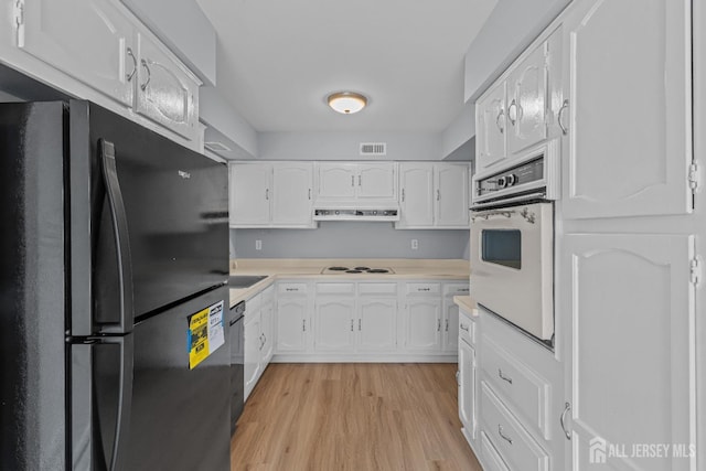 kitchen featuring light wood finished floors, black appliances, light countertops, extractor fan, and white cabinetry