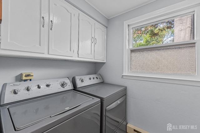 clothes washing area featuring cabinet space, washer and dryer, and ornamental molding