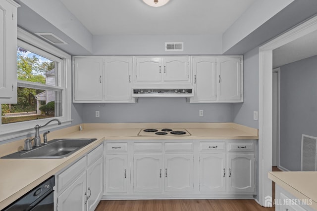 kitchen with black dishwasher, light countertops, visible vents, and white cabinets