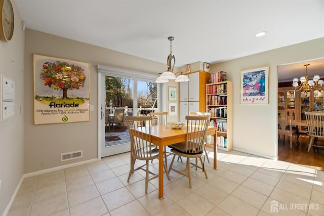 dining space with light tile patterned floors, visible vents, baseboards, and an inviting chandelier