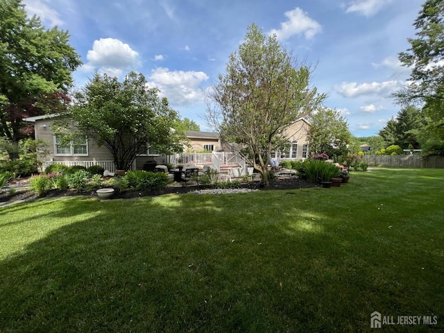 view of yard with fence and a deck