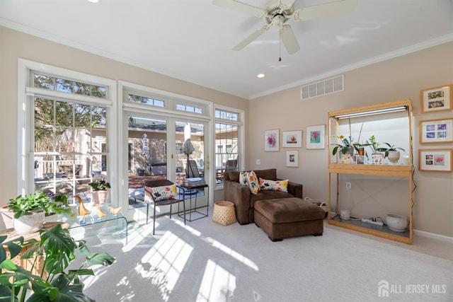 living area featuring visible vents, a ceiling fan, crown molding, french doors, and carpet flooring