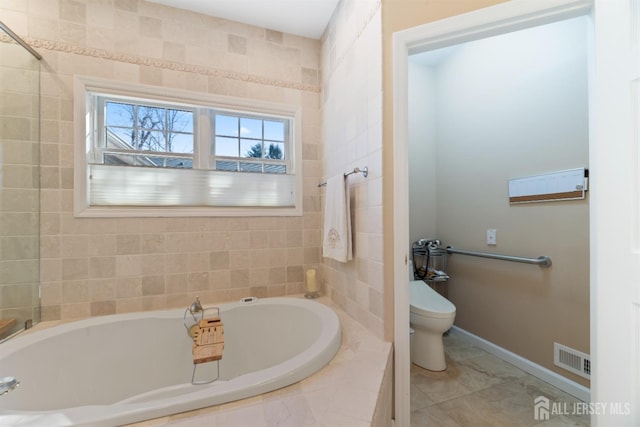 bathroom featuring baseboards, a garden tub, visible vents, and toilet