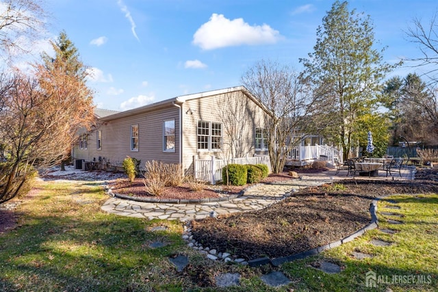 view of side of property with central AC, a yard, and a patio