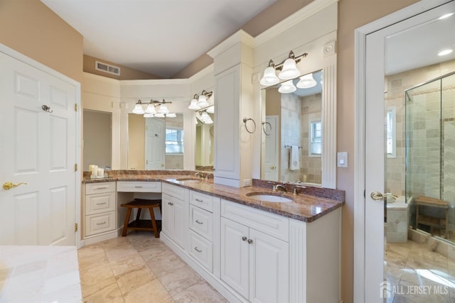 full bath featuring visible vents, a sink, a shower stall, and double vanity