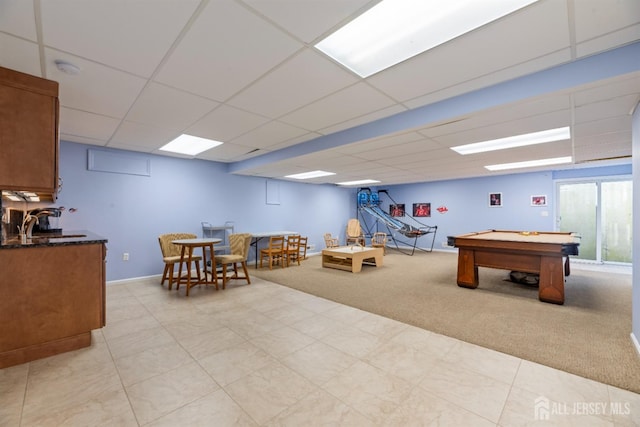 playroom with a paneled ceiling, light carpet, a sink, and baseboards