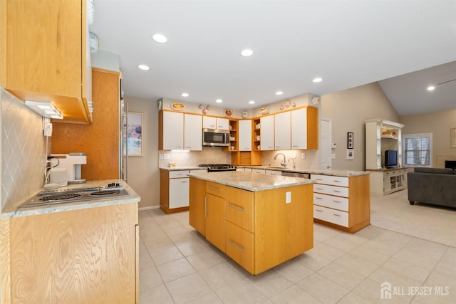 kitchen featuring recessed lighting, appliances with stainless steel finishes, white cabinetry, a kitchen island, and a peninsula