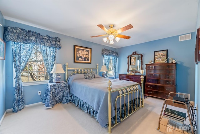 carpeted bedroom with ceiling fan, multiple windows, visible vents, and baseboards