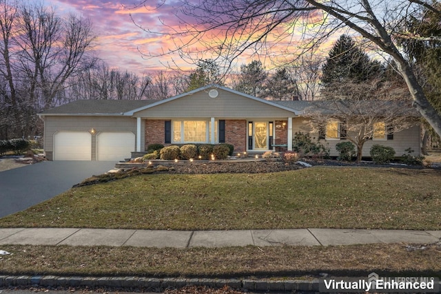 single story home featuring a front yard, brick siding, driveway, and an attached garage