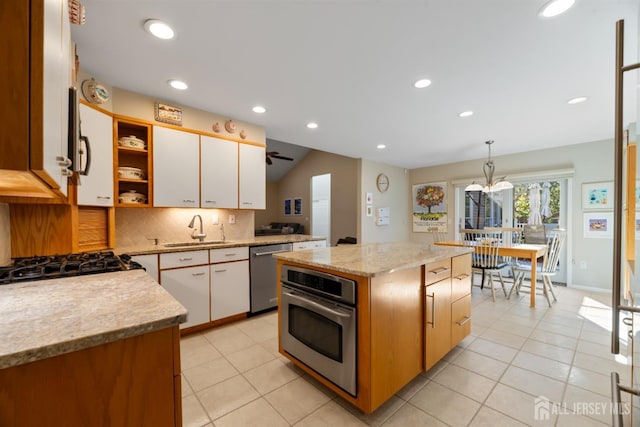 kitchen featuring a kitchen island, appliances with stainless steel finishes, hanging light fixtures, white cabinetry, and open shelves