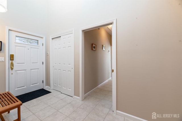 foyer featuring light tile patterned floors and baseboards