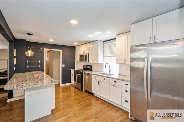 4 Woodrow St, Middlesex, NJ 08846 - kitchen with stainless steel appliances, recessed lighting, white cabinetry, a center island, and light stone countertops