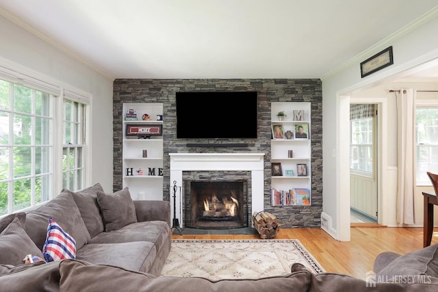 70 Surrey Ln, Woodbridge Proper, NJ 07067 - living room featuring ornamental molding, wood finished floors, a stone fireplace, and built in shelves