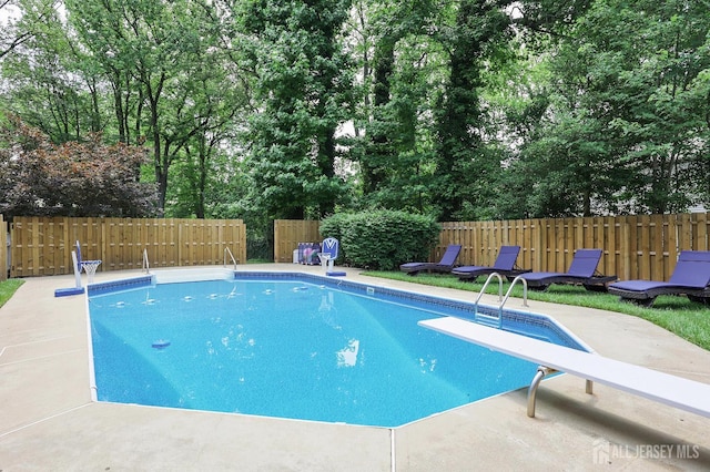 70 Surrey Ln, Woodbridge Proper, NJ 07067 - view of swimming pool featuring a diving board, a fenced backyard, a patio area, and view of wooded area