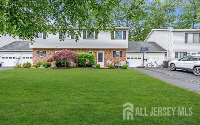 2 Elizabeth Ct, Howell, NJ 07731 - view of front of home with brick siding, a front yard, a garage, and driveway