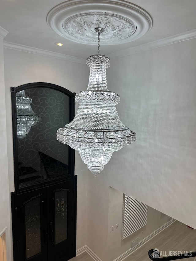 35 NE Bennett Rd, Old Bridge, NJ 07747 - details with a tray ceiling, an inviting chandelier, wood finished floors, and crown molding