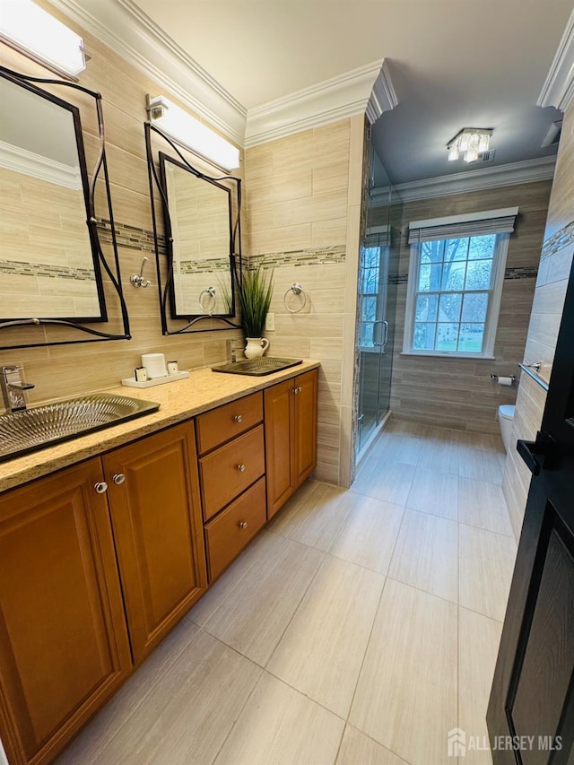 35 NE Bennett Rd, Old Bridge, NJ 07747 - bathroom featuring crown molding, a stall shower, double vanity, toilet, and tile walls