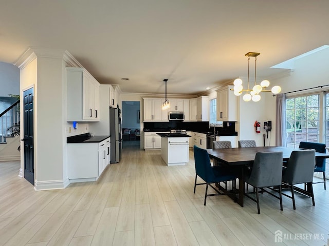 35 NE Bennett Rd, Old Bridge, NJ 07747 - dining space with crown molding, a chandelier, and light wood finished floors