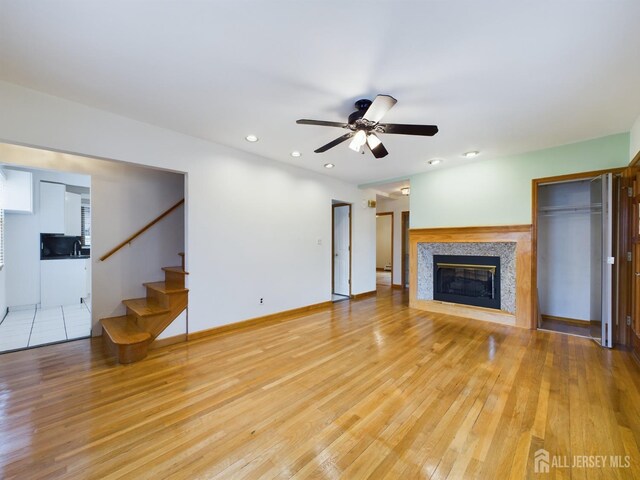 unfurnished living room with light hardwood / wood-style flooring and ceiling fan