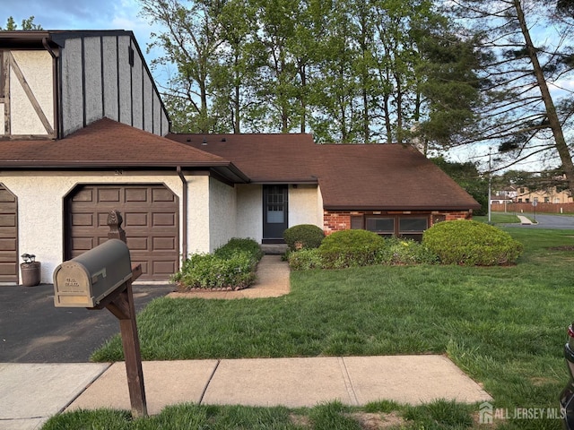 view of front facade with a garage, stucco siding, driveway, and a front yard