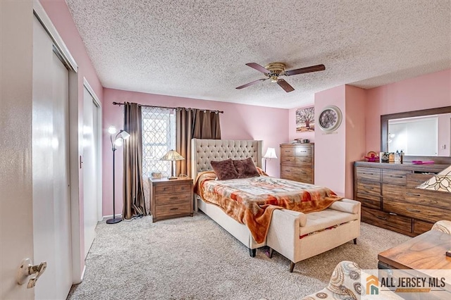 carpeted bedroom with ceiling fan and a textured ceiling