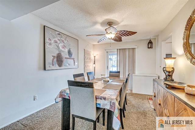 carpeted dining room with ceiling fan and a textured ceiling