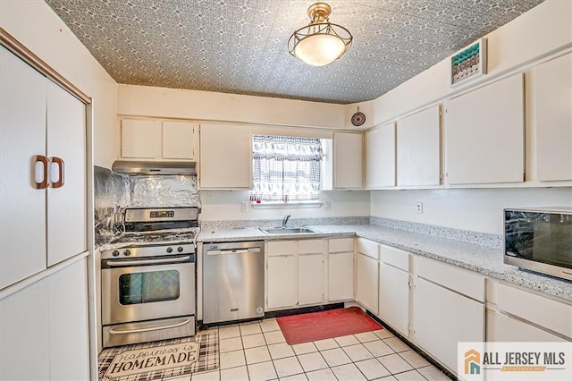 kitchen with light tile patterned floors, stainless steel appliances, sink, and white cabinets