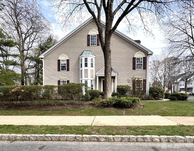 traditional-style home featuring a front yard