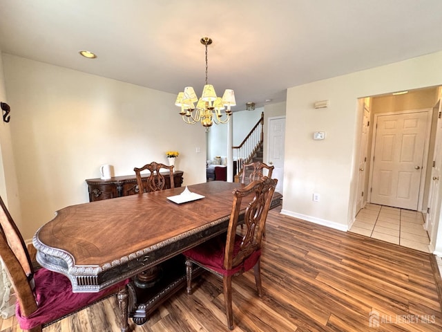 dining area with stairs, baseboards, an inviting chandelier, and wood finished floors