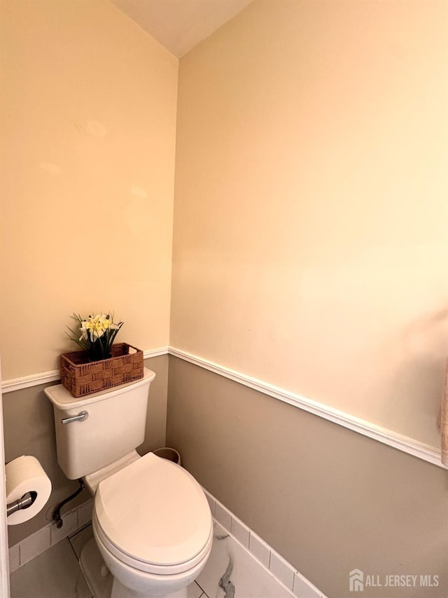bathroom with baseboards and toilet