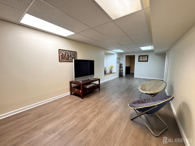 interior space with wood finished floors, baseboards, and a drop ceiling