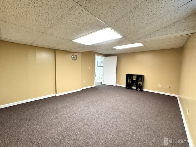 finished basement with baseboards, carpet flooring, and a paneled ceiling