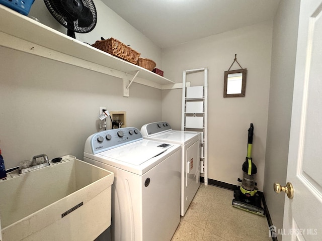 laundry room featuring laundry area, washing machine and dryer, a sink, baseboards, and light floors