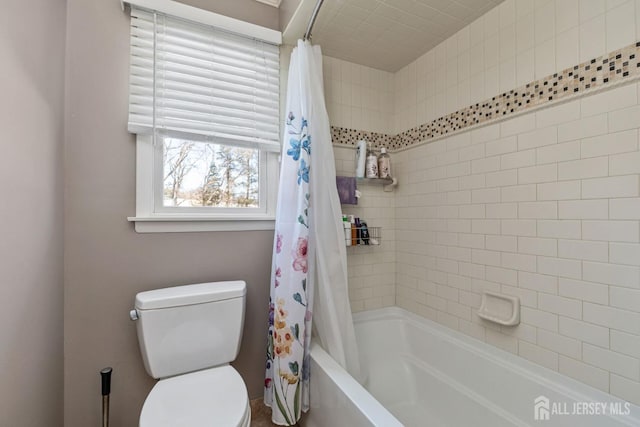 bathroom featuring shower / bathtub combination with curtain and toilet