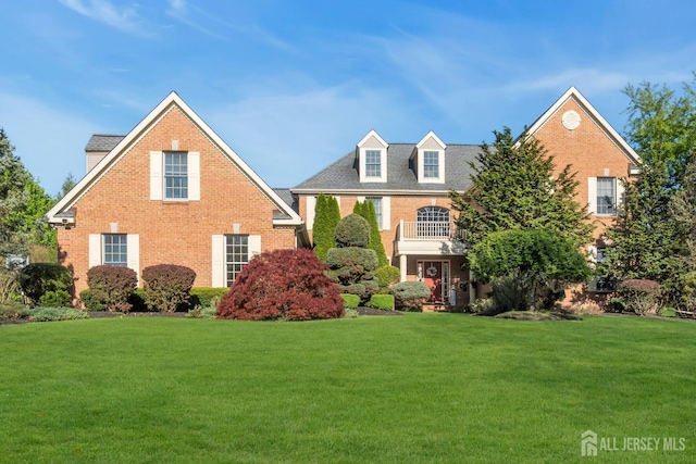 view of front of house with brick siding and a front lawn