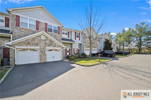 21 Capica Ct Unit 89, South Amboy, NJ 08879 - view of property with stone siding, driveway, an attached garage, and a residential view