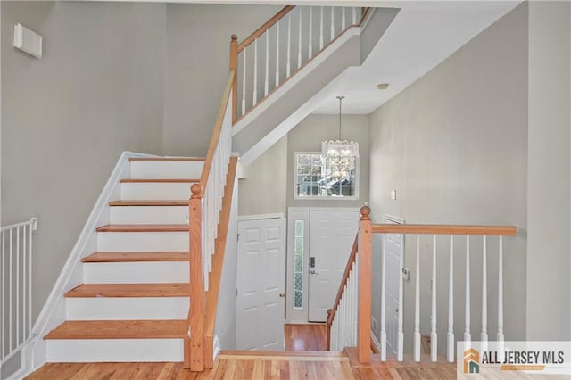 21 Capica Ct Unit 89, South Amboy, NJ 08879 - stairway featuring wood finished floors, a chandelier, and a towering ceiling